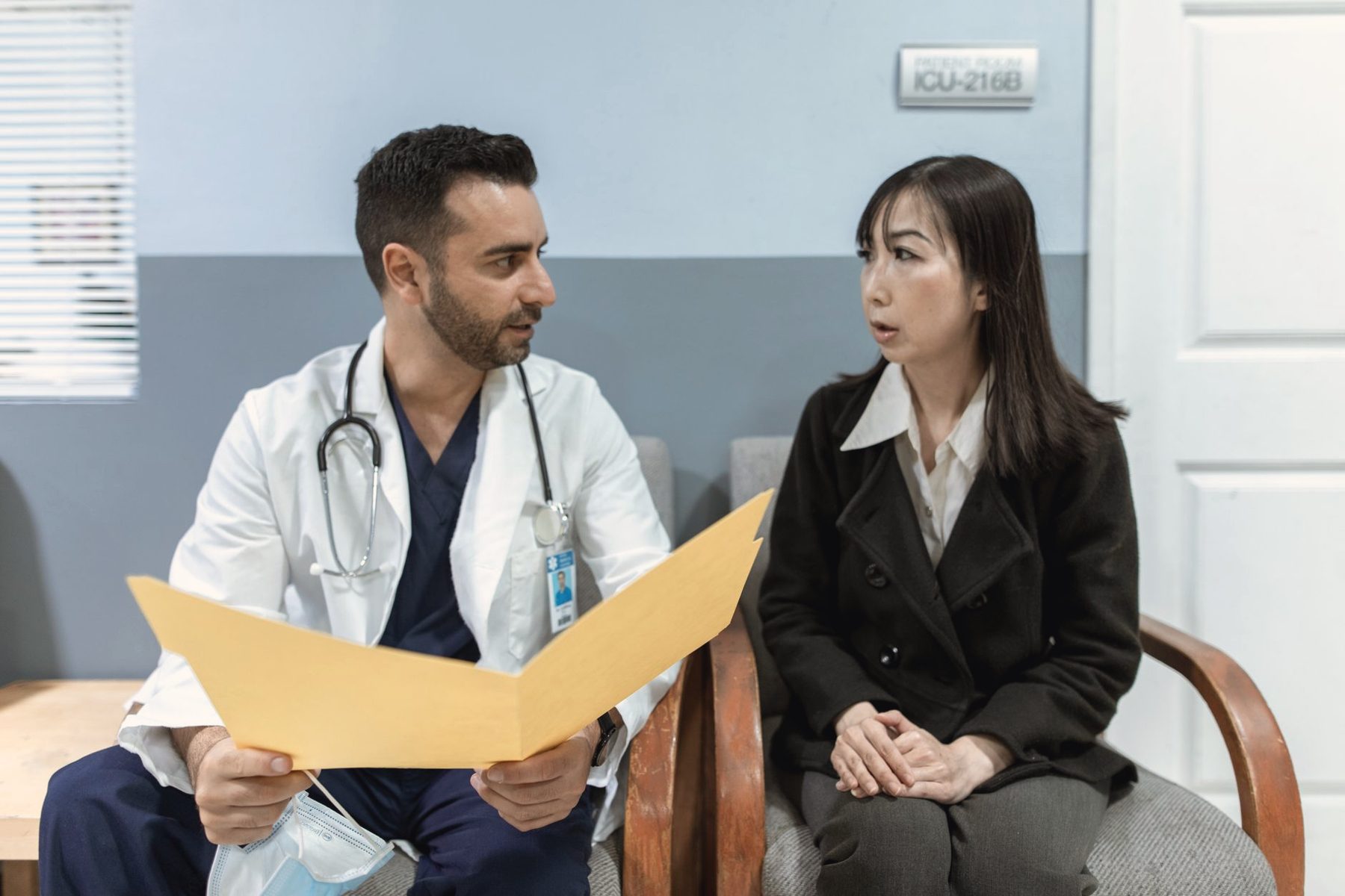A doctor reviewing a chart with a patient in a clinic