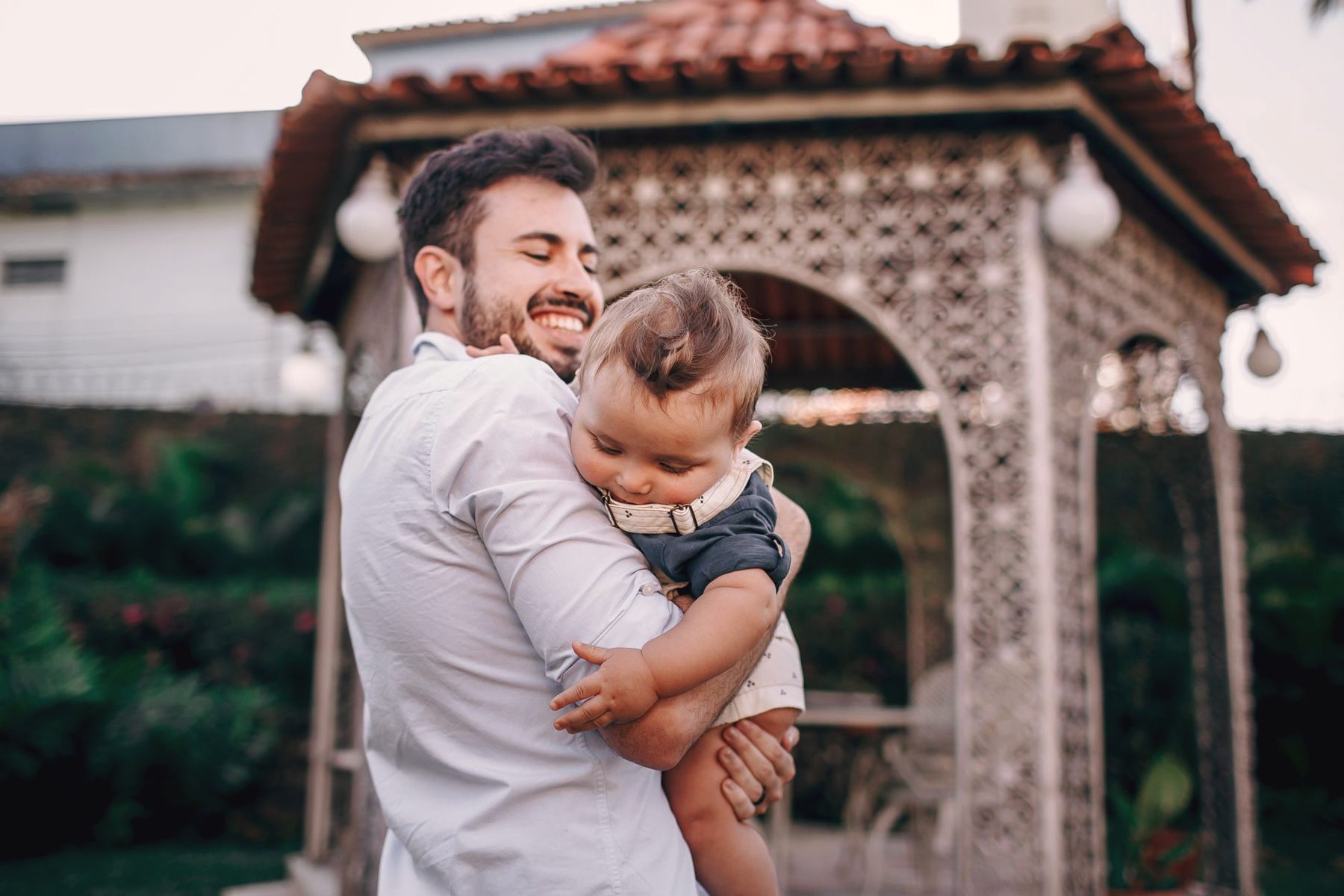 A father holding his baby in a garden